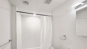 A bathroom with a white bathtub, a toilet, a sink, and a shower curtain. - Ideal 2BD Retreat | Sleeps 6 | Center City Philly (Philadelphia)