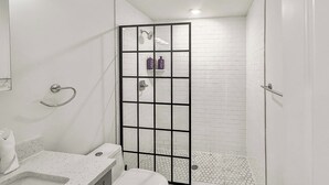 A bathroom with a shower, toilet, and sink.