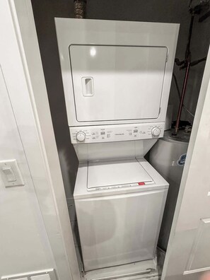 A compact, white laundry room with a front-loading washing machine and a dryer.