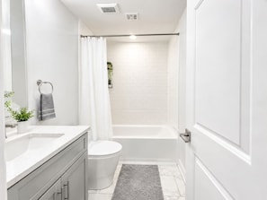 Un baño moderno con inodoro, lavamanos y zona de ducha.