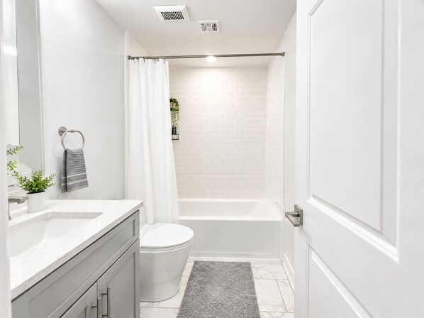 A modern bathroom with a toilet, sink, and shower area.