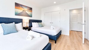 Habitación de hotel con dos camas, una mesita de noche, un cuadro y un armario.