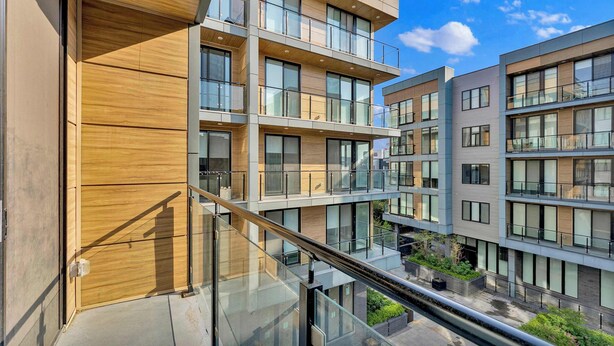 Un edificio residencial de varios pisos con balcones, ventanas amplias y un diseño arquitectónico moderno.