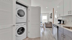 A modern kitchen with a coffee maker, a dishwasher, and a sink.