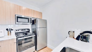 A modern kitchen with stainless steel appliances, including a microwave, oven, and refrigerator.