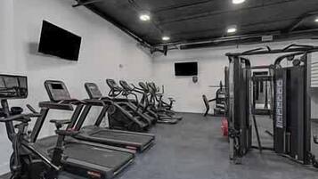 A gym with treadmills, elliptical machines, and weightlifting equipment.