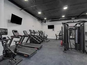 A gym with treadmills, elliptical machines, and weightlifting equipment.