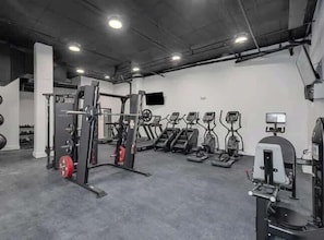 A gym with treadmills, weight machines, and a squat rack.
