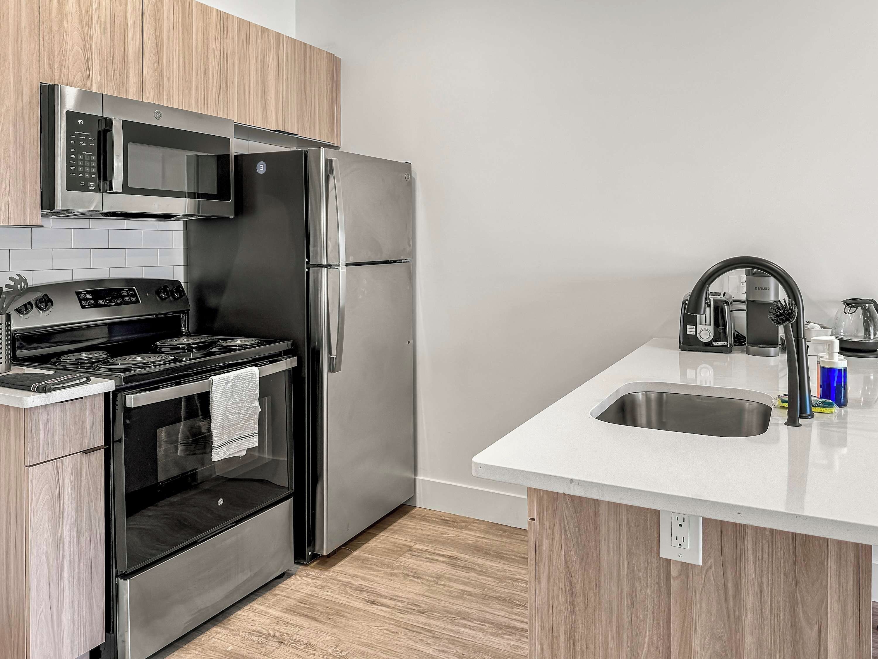 Een moderne keuken met roestvrijstalen apparatuur, een inbouwoven en een gootsteen met een kraan.