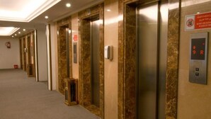 A corridor with multiple elevators, each with a marble finish and a digital display. - Al Massa Grand Hotel (Makkah)