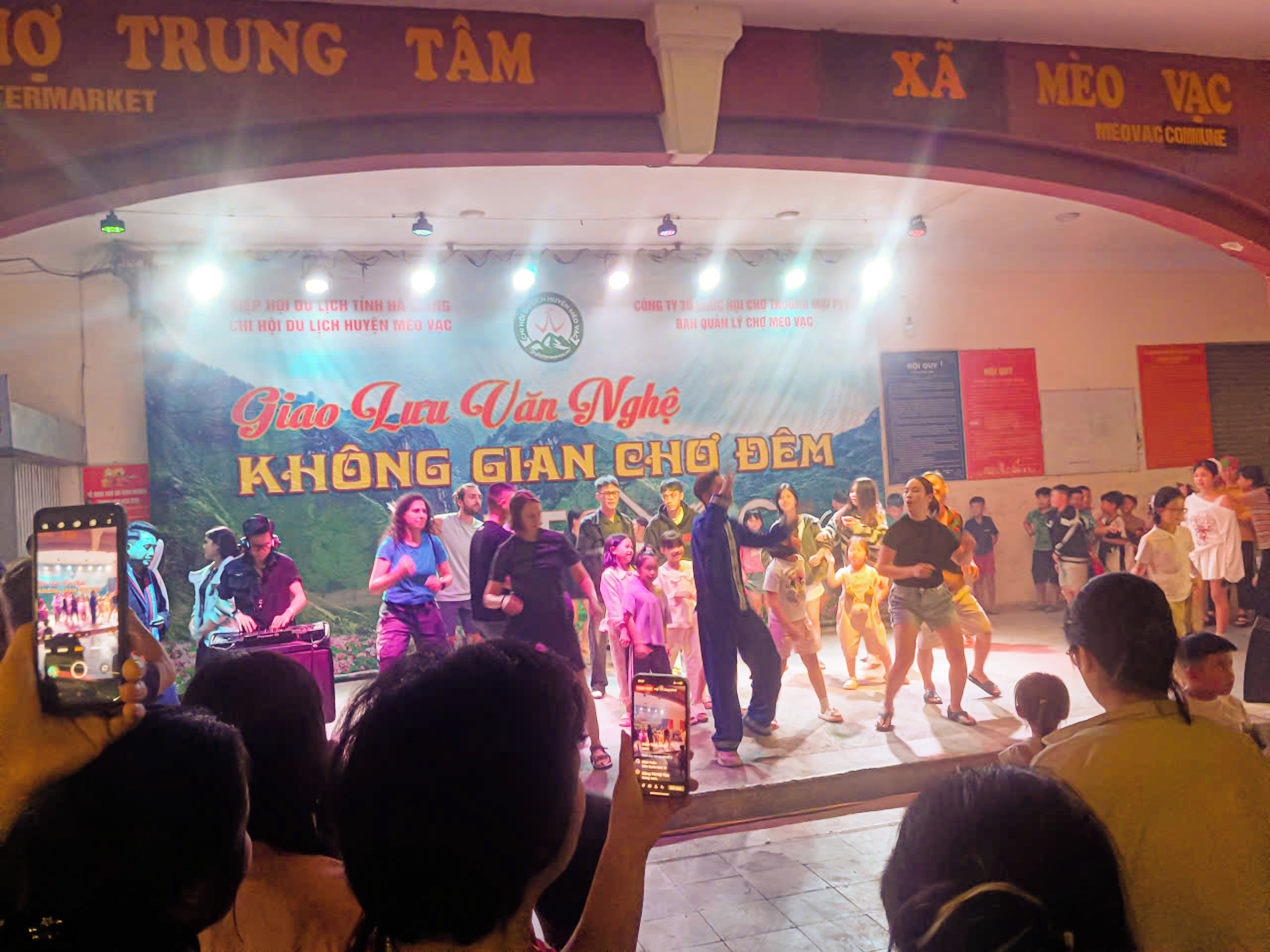 A stage with a group of people performing in front of an audience.