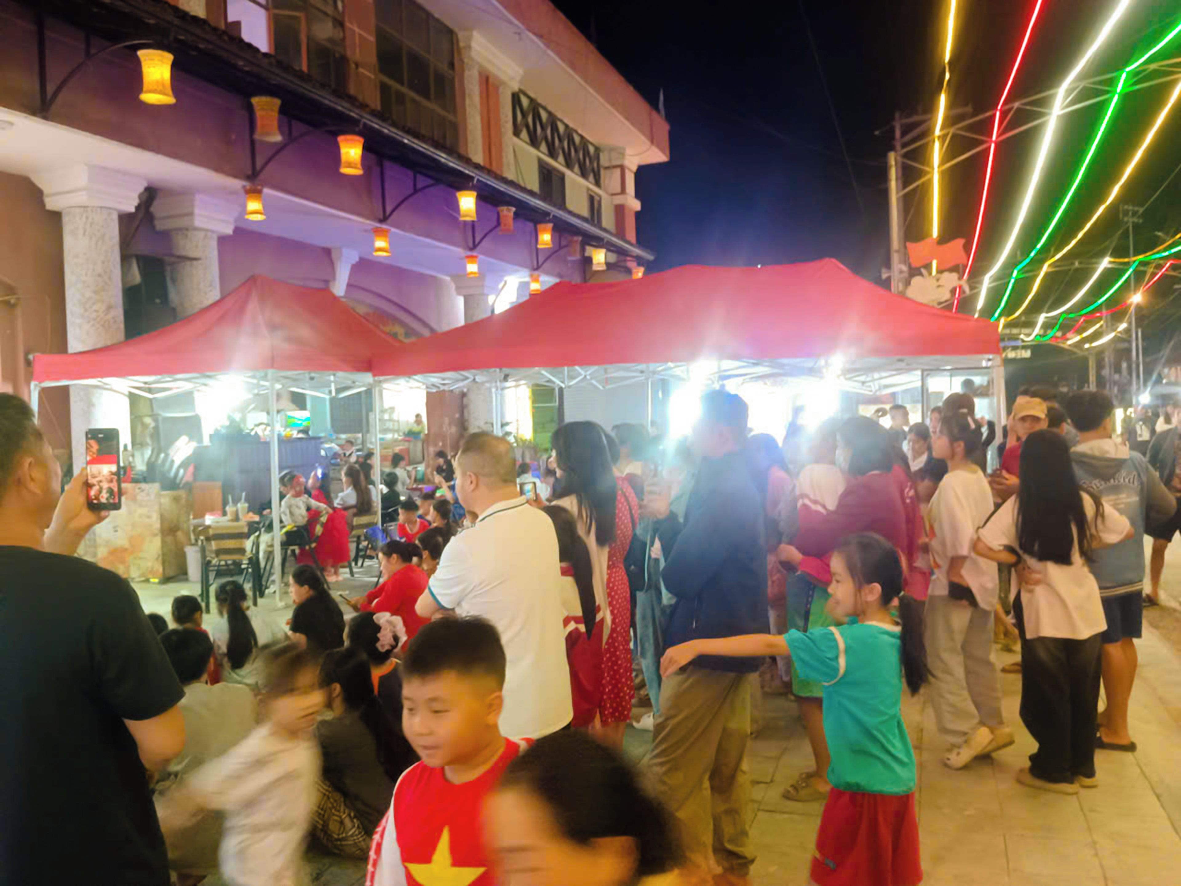 Un mercado al aire libre concurrido, lleno de gente y puestos.