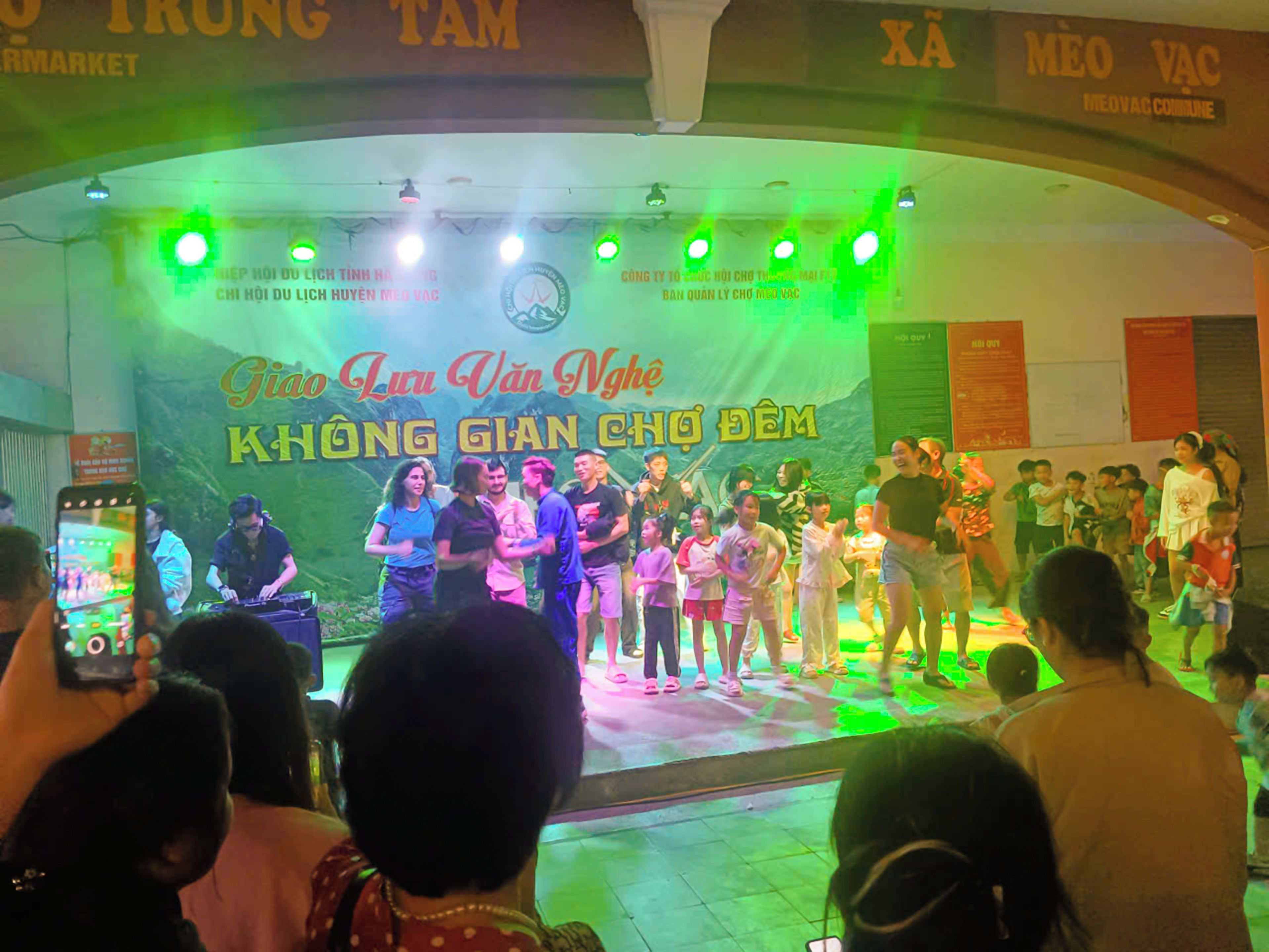 A stage with a group of people performing, surrounded by an audience.