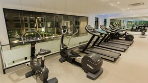 Ein Fitnessstudio mit mehreren Laufbändern, Ergometer und Crosstrainern.