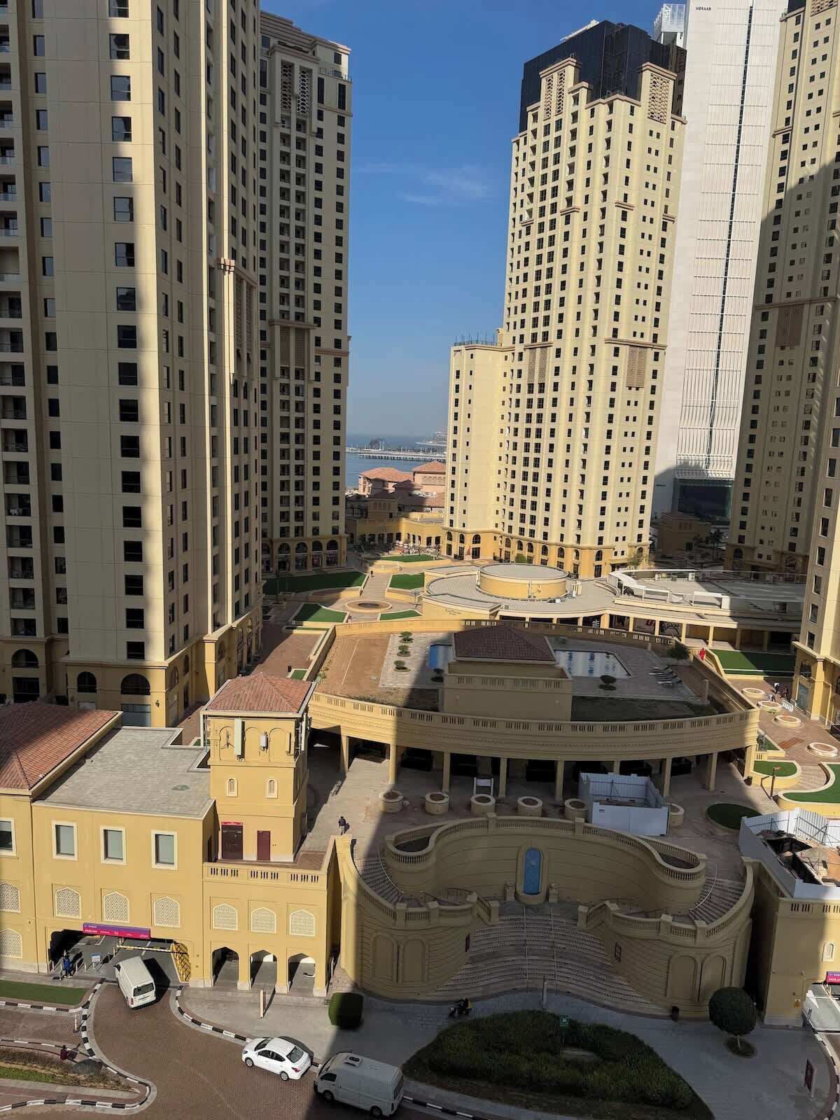 Un complex residencial de grattacels amb diversos blocs d'apartaments, un pati central i vistes al mar.