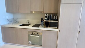 A modern kitchen with a stainless steel oven, microwave, and sink. - Gorgeous luxury studio - Exquisite Palm View (Palm Jumeirah)