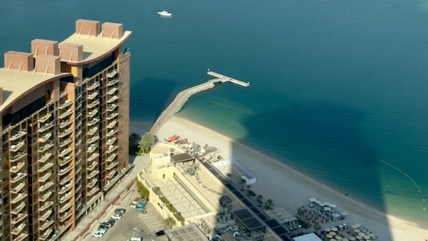 A coastal cityscape with a prominent sail-shaped building, a marina, and a densely built residential area. - Gorgeous luxury studio - Exquisite Palm View (Palm Jumeirah)