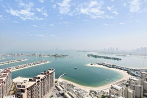 A coastal cityscape with a marina, high-rise buildings, and a beach.