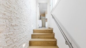 A staircase with wooden steps and a white brick wall.