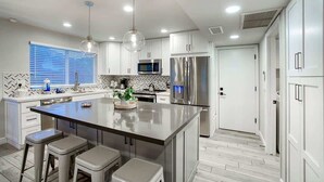 A modern kitchen with a central island, stainless steel appliances, and pendant lighting. - Private Pool & Putting Green | Fire Pit Patio (Scottsdale)