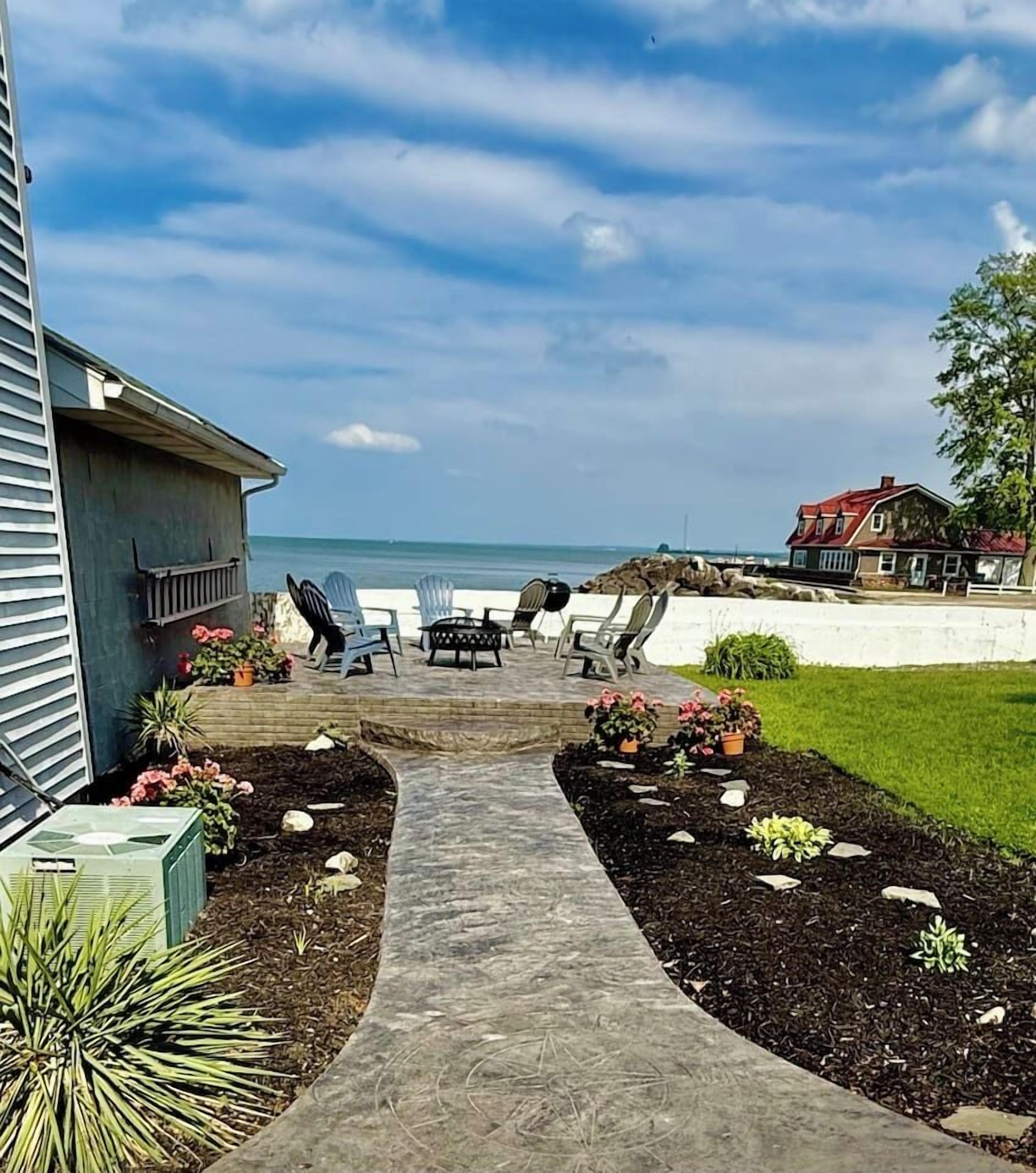 A pathway leading to outdoor seating with a view of the ocean.
