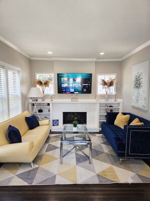 A living room with a fireplace, a television, and two sofas.