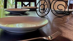 A dining table with a plate, fork, and a decorative metal stand.