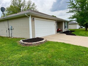 A residential garage with a driveway leading to a house.