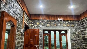 A room with stone walls, wooden door, and windows. - Mandeva Wooden castle (Bhikyasain)