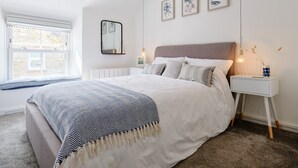 2 habitaciones, tabla de planchar con plancha y muebles diferentes