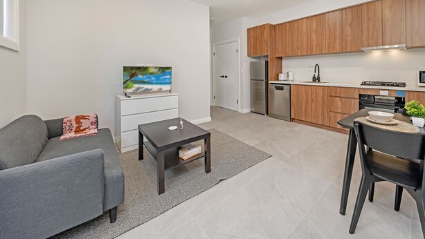 Un apartamento moderno con sala de estar, kitchenette y comedor.