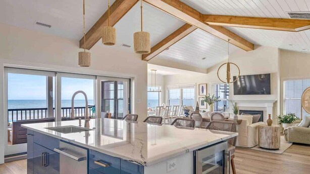 A spacious kitchen with a large island, wooden beams, and a view of the sea. - Beachfront Luxury Villa in Dewey Beach, Two Master Bedroom (Dewey Beach)