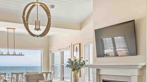 A spacious living room with a fireplace, comfortable seating, and a large TV mounted on the wall. - Beachfront Luxury Villa in Dewey Beach, Two Master Bedroom (Dewey Beach)
