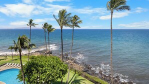 A poolside view overlooking a beach with palm trees and ocean. - Watch Whales from your Bed - Double Master Sunset Suite (Kihei)