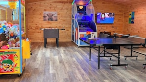A room with a foosball table, a ping pong table, and a claw machine. - Conestoga Wagon (Wellsboro)