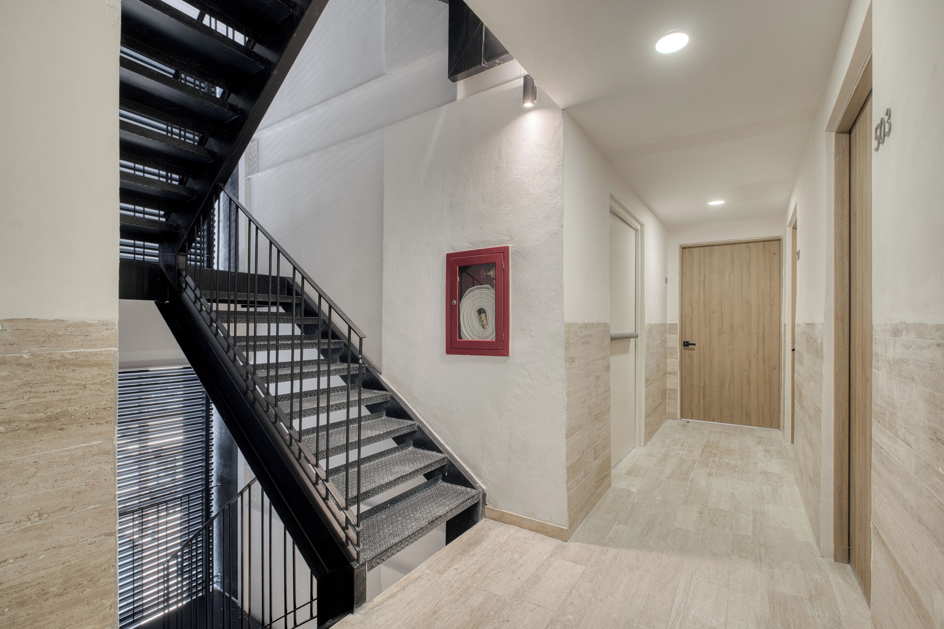 A modern interior with a staircase, a framed picture, and a wooden door.