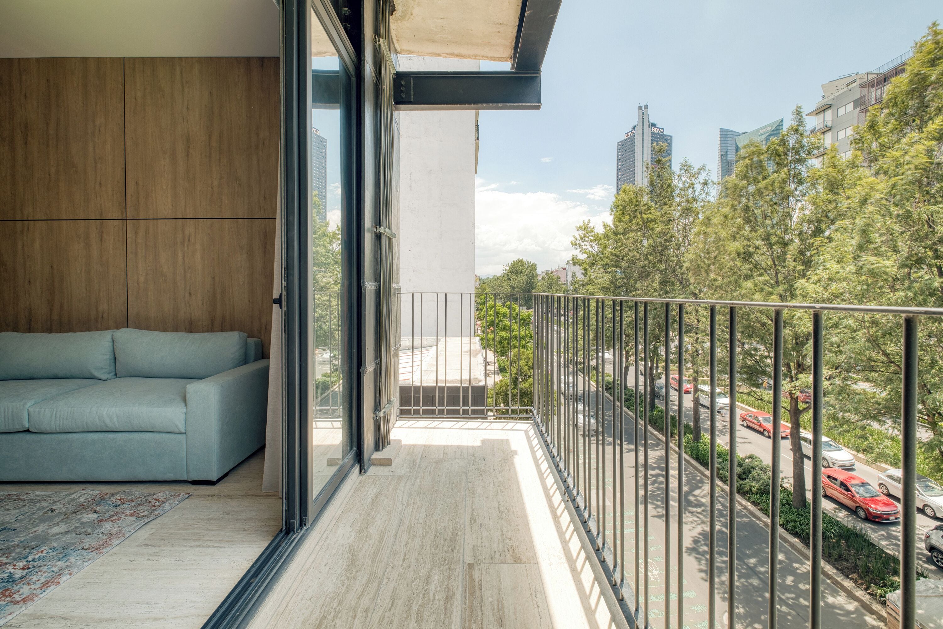 Un balcone moderno con divano e vista sulla città.