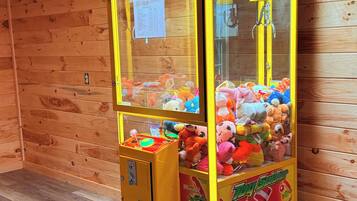 A claw machine with a Toy Soldier theme, filled with plush toys.