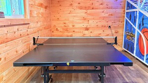 A ping pong table in a room with wooden walls and a basketball-themed poster. - Tent and Tear Drop Electric site 10 (Wellsboro)