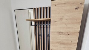 A room with a wooden bench, a mirror, and a sliding door. - ELODIA LUXURY Apartment, WiFi, terrace, kitchen, towels (Heidenheim an der Brenz)