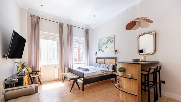 A modern bedroom with a bed, bedside table, TV, and a desk with chairs. - Modern Apartment in Koblenz Near Mosel River (Koblenz)