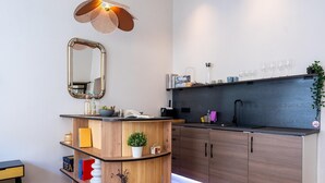A modern kitchen with a curved wooden island, a black countertop, and a dark backsplash. - Modern Apartment in Koblenz Near Mosel River (Koblenz)