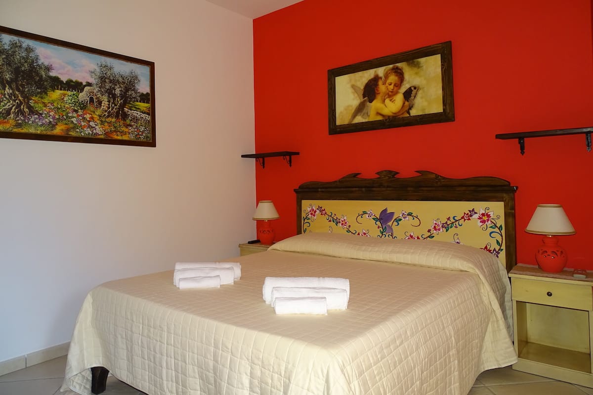 A bedroom with a bed, two bedside tables, and two lamps.