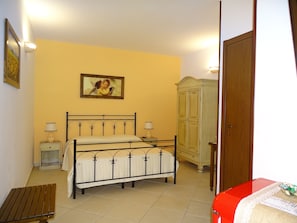A bedroom with a bed, bedside tables, a wardrobe, and a bench. - Sole del Mediterraneo (Otranto)