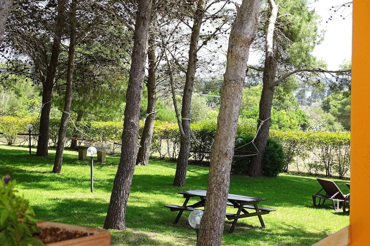 A garden with picnic tables and a hammock.