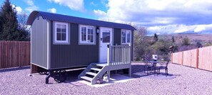 A small, single-story cabin with a porch and a staircase leading to the door. - Cabin for 2 With Walks, Wifi, bat and Restaurant (Forfar)