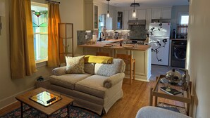 Ein gemütliches Wohnzimmer mit einer Couch, einem Couchtisch und einem Essbereich mit Tisch und Stühlen.