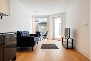 Deluxe Apartment | Living area | 32-inch TV with satellite channels