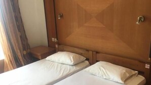 Una cama doble con cabecera de madera y dos almohadas.