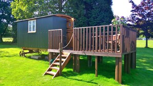 A wooden deck with a staircase leading to a small cabin-like structure. - Shepherd's Hut in Romsey With Fire Pit (Romsey)